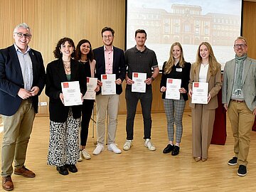 Gruppenbild mit 7 Studierenden und den beiden Bürgermeistern Grunert und Riehle im Technischen Rathaus.