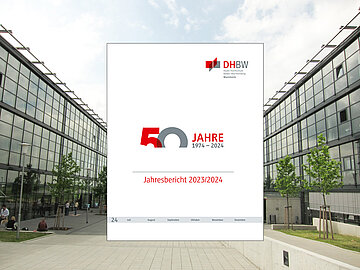 Im Hintergrund das Außengelände zwischen den Gebäuden D und E am Campus der DHBW Mannheim, im Vordergrund das weiße Cover des Jahresberichts 2023/2024 mit dem 50-Jahr-Logo der DHBW Mannheim in der Mitte.