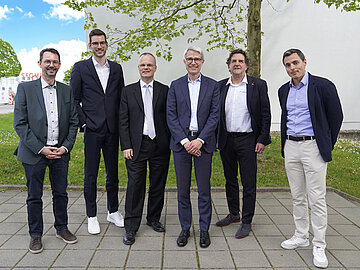 Gruppenbild mit 6 Männern in Anzug auf dem Außengelände der DHBW Mannheim. 