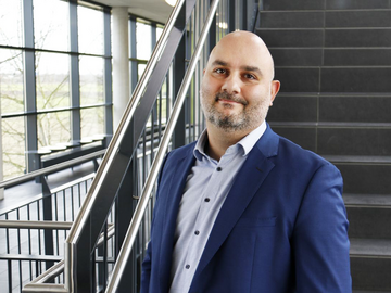 Porträt Prof. Dr. Narbeh Haddad im lichtdurchfluteten Treppenhaus des D-Gebäudes am Campus Coblitzallee