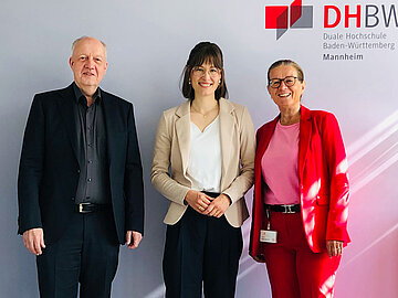 Frau Professorin Nicole Wimmesberger steht lächelnd in der Mitte, links neben Ihr steht Rektor Prof. Dr. Jörg Baumgart und rechts steht Prof. Dr. Beate Land