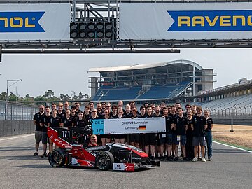 Gruppenfoto auf der Rennstrecke mit dem Rennwagen "Caro"