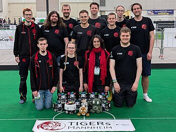 TIGERs Mannheim posieren für ein Gruppenfoto mit ihren Fußballrobotern