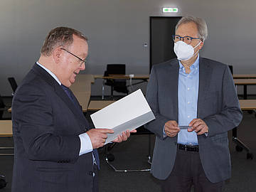 Links Rektor der DHBW Mannheim, Prof. Dr. Georg Nagler, liest aus der Ruhestandsurkunde. Rechts der ausscheidende Professor Dr. Rolf Fuhrmann. 