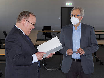 Links Rektor der DHBW Mannheim, Prof. Dr. Georg Nagler, liest aus der Ruhestandsurkunde. Rechts der ausscheidende Professor Dr. Rolf Fuhrmann. 