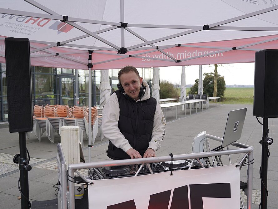 DJ an einem DJ-Pult auf dem Außengelände der DHBW Mannheim