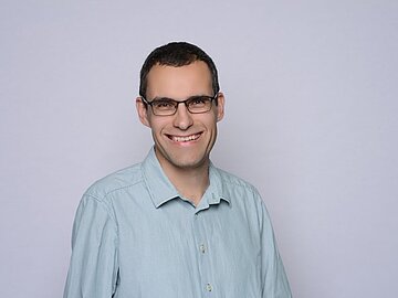 Portraitaufnahme von Prof. Dr. Michael Stützer. Er schaut lächelnd in die Kamera.