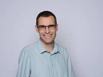 Portraitaufnahme von Prof. Dr. Michael Stützer. Er schaut lächelnd in die Kamera.