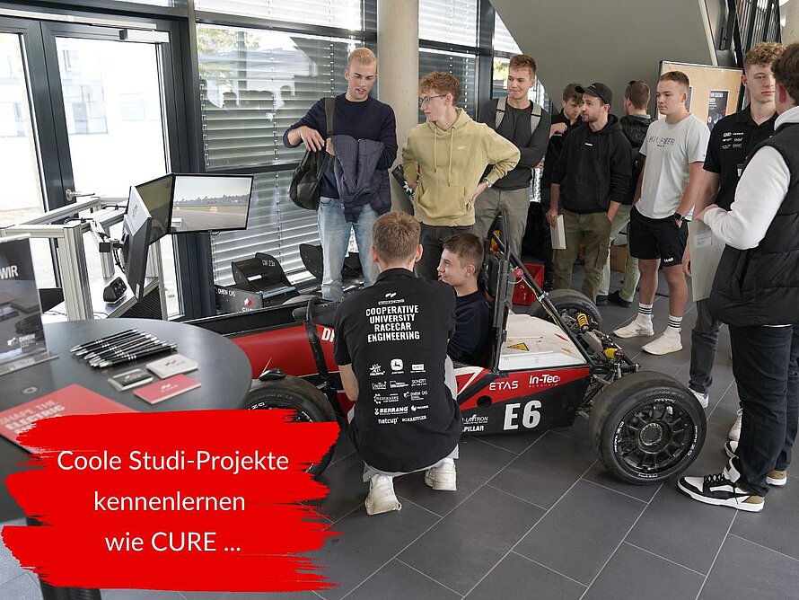 Studierende stehen neben einem E-Rennwagen des CURE-Teams der DHBW Mannheim und informieren sich über das studentische Rennsportprojekt. Im Bild steht: Coole Studi-Projekte kennenlernen wie CURE
