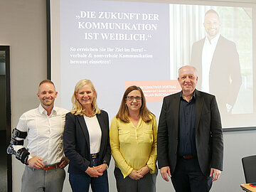 Gruppenbild mit 4 freundlich aussehenden Personen vor einer Präsentation von Balian Buschbaum, dem Speaker des Abends. 