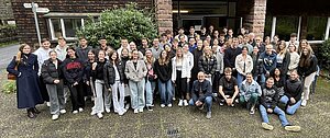 Gruppenfoto mit ca. 40 Studierenden vor einem Steingebäude im Oktober 2024.