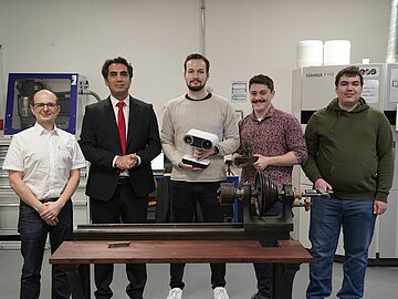 Gruppenbild mit 5 Personen hinter der Drehbank im Additiven Fertigungslabor der DHBW Mannheim