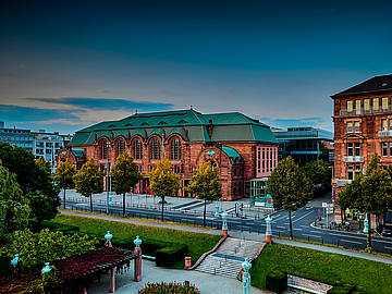 Blick auf den Mannheimer Rosengarten in der Abenddämmerung. Davor der Friedrichsplatz.