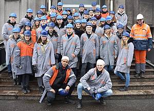 Gruppe von Studierender der Studienrichtung International Business in Schutzkleidung vor dem Stahlwerk Luxemburg.