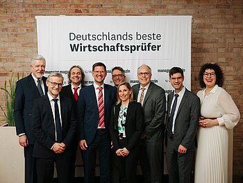 Gruppenbild mit 7 Männern und 2 Frauen vor dem Banner "Deutschlands beste Wirtschaftspfüder". 