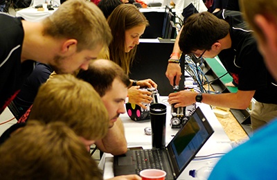 Studierendenprojekte DHBW Mannheim Mehrere Studierende der DHBW Mannheim arbeiten gemeinsam an Laptops und kleinen Robotern