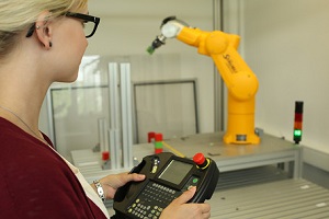 Studentin bedient einen Knickarmroboter im Labor Studienarbeiten der Elektrotechnik an der DHBW Mannheim
