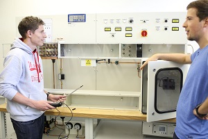 Labor Gebäudetechnik im Studiengang Maschinenbau an der DHBW Mannheim. Zwei Studenten an einer Modell-Klimaanlage, der linke von beidem mit Messgerät in der Hand. 