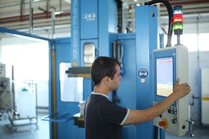 Student (von der Seite zu sehen) bedient eine Spritzgussanlage im Labor Mechanische Verfahrenstechnik des Studiengangs Maschinenbau an der DHBW Mannheim