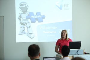 Internet-of-Things-Labor im Studiengang Wirtschaftsinformatik an der DHBW Mannheim. Studentin steht hinter einem Laptop vor einer Präsentation; auf der Projektion wird ein Roboter gezeigt.