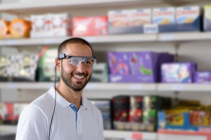 Mann mit Eye-Tracking-Brille vor einem Verkaufsregal im Eye tracking Lab der DHBW Mannheim