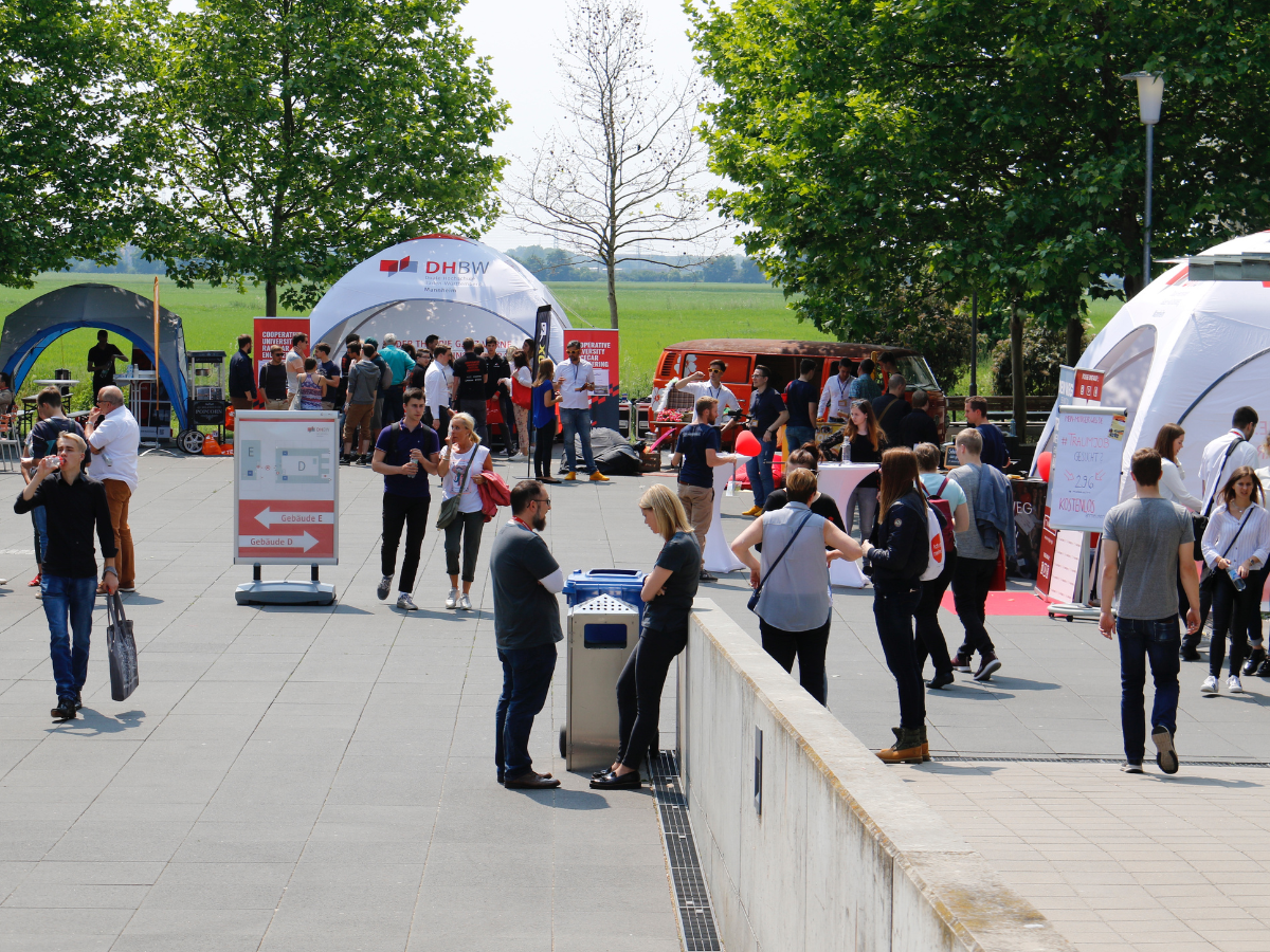 Außengelände der DHBW Mannheim zwischen den Gebäuden D und E am sonnigen und gut besuchten Infotag 2019. 