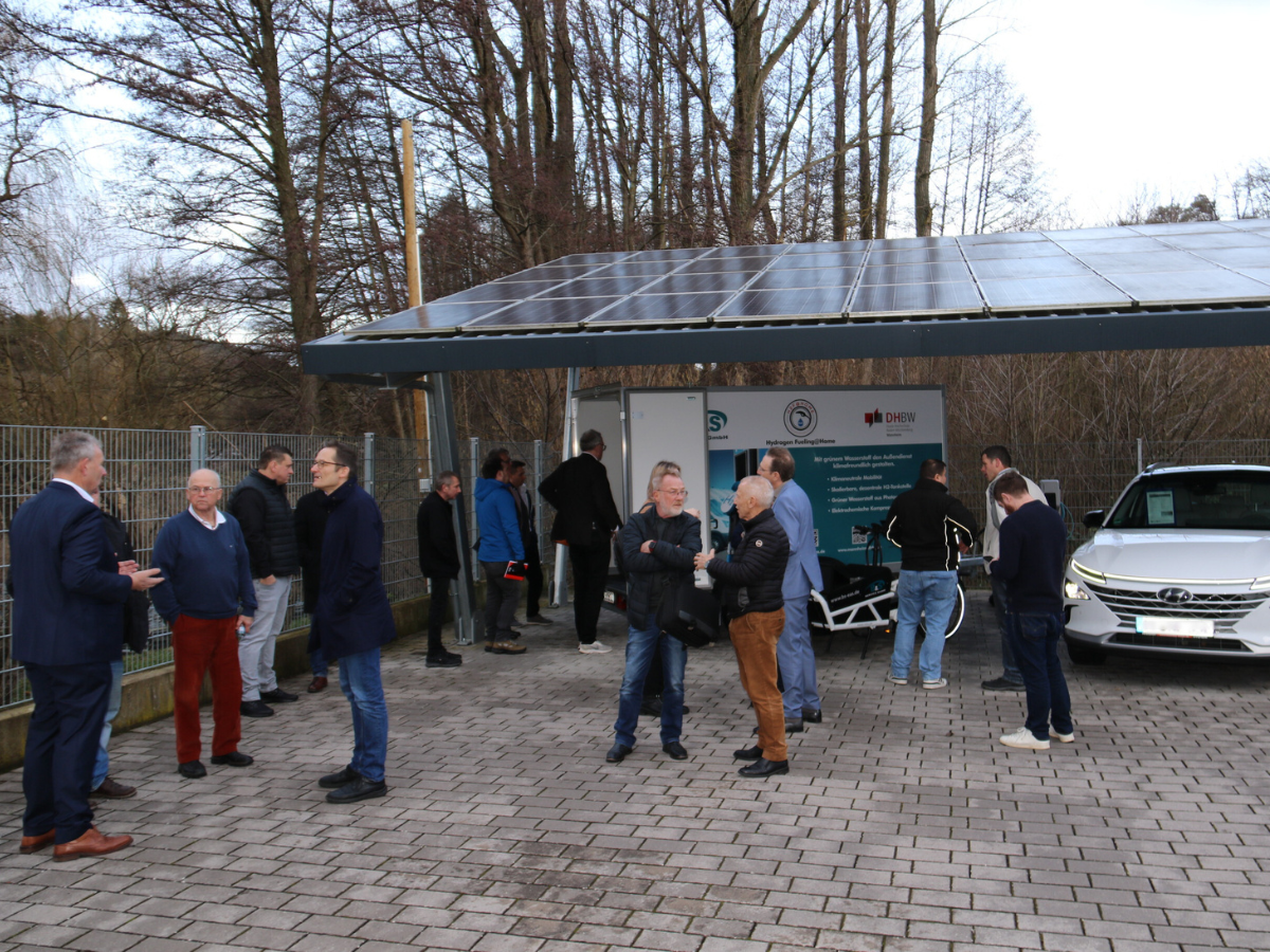 Gruppe von ca. 20 Menschen, die sich auf dem Außengelände der B&S Service GmbH in Kleingruppen unterhalten.