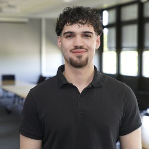 Portraitaufnahme von DHBW-Student David Reske, der freundlich lächelnd in die Kamera blickt.