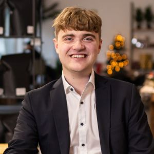 Porträt von Robin Schmiedekind, der als Student des Studiengangs BWL-Bank freundlich in die Kamera blickt. 