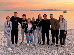Gruppenbild mit 9 Studierenden bei Sonnenuntergang am Meer.