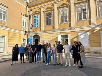 Gruppenbild mit 12 Studierenden und 3 Lehrenden vor der PAR-Universität in Rijeka